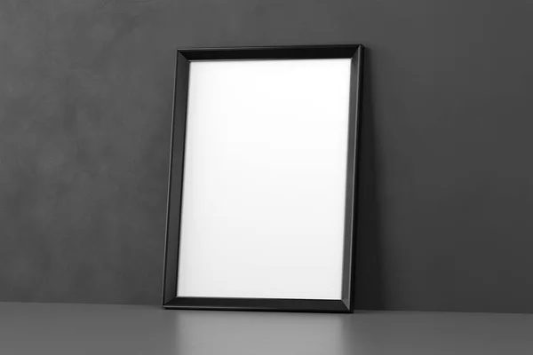 Blank wooden picture frame leaning over dark wall — Stock Photo, Image