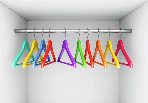 Colorful hangers on cloth rail in wardrobe — Stock Photo, Image