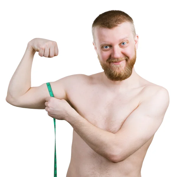 Vousatý muž měří jeho malou biceps — Stock fotografie