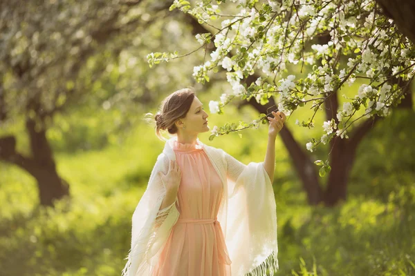 Lycklig kvinna nära det blommande äppelträdet — Stockfoto