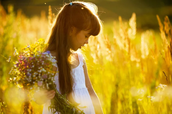 Flicka med en bukett av vilda blommor — Stockfoto