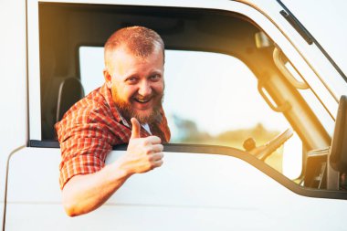 Bearded driver sits in the car and shows that everything is fine clipart