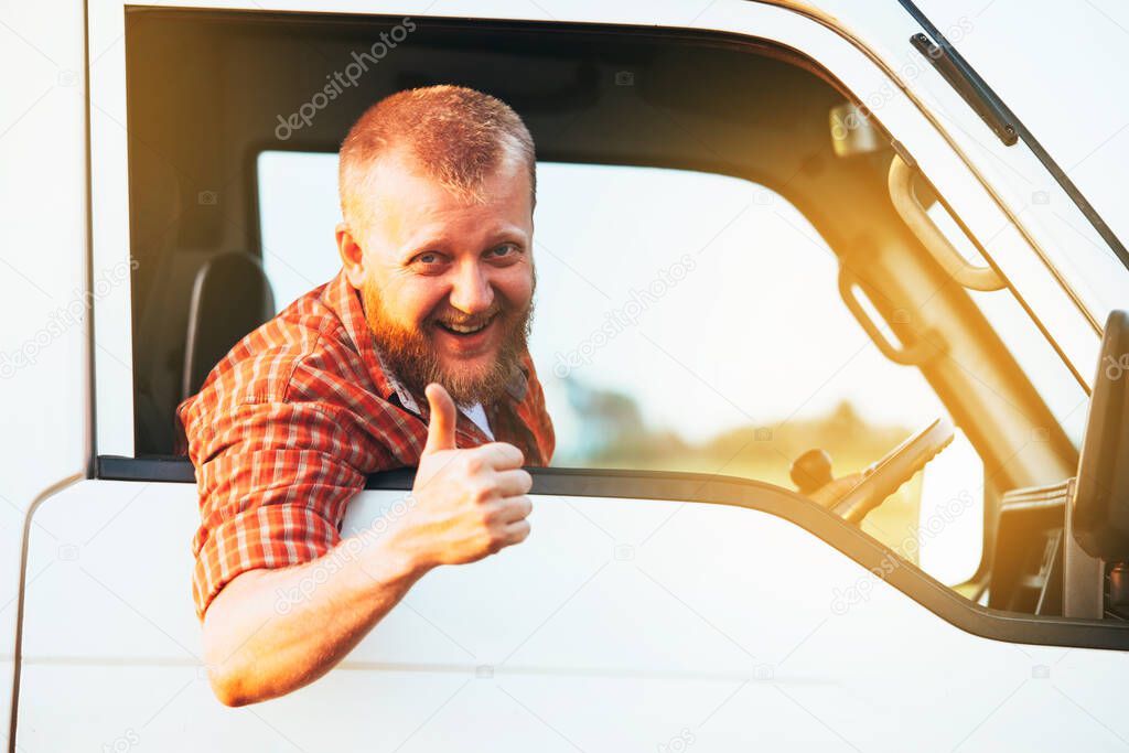 Bearded driver sits in the car and shows that everything is fine