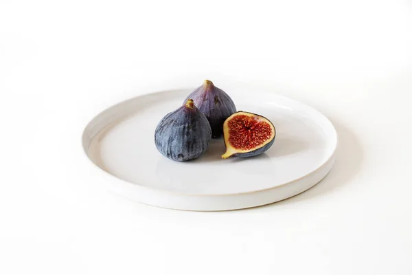 Deux Figues Entières Une Moitié Sur Une Assiette Blanche — Photo