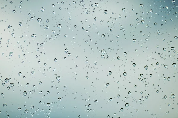 Regentropfen ergießen sich auf das Glas — Stockfoto