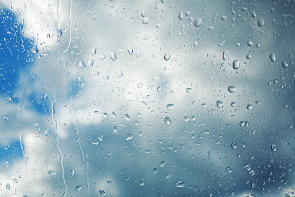 Rain drops running down clear glass