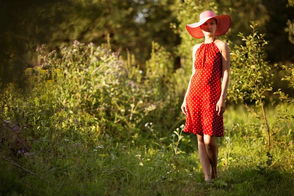 Donna con un cappello cammina a piedi nudi — Foto Stock