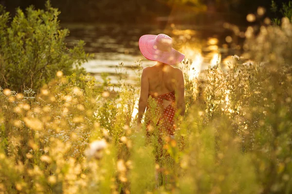 Femme avec chapeau sur le front de mer lors d'une soirée d'été — Photo