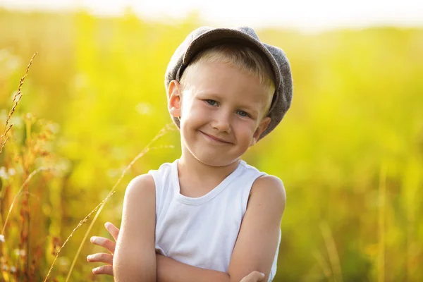 Glad liten pojke i en grå mössa — Stockfoto