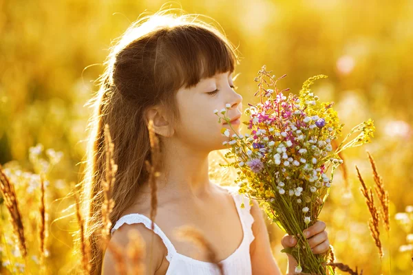 Menina feliz com um buquê de flores silvestres — Fotografia de Stock