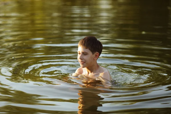 Menino feliz se divertindo nadando na água — Fotografia de Stock