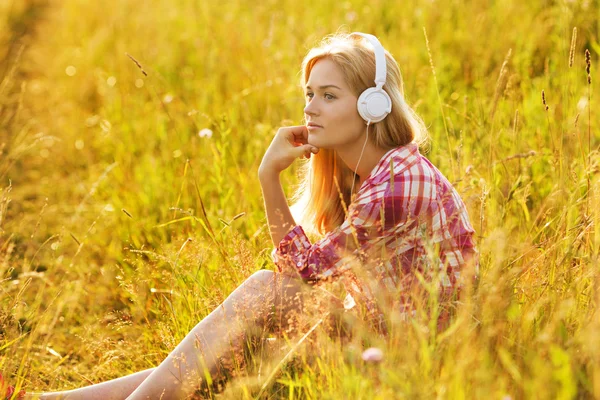 Gelukkig meisje luisteren naar muziek op hoofdtelefoon — Stockfoto