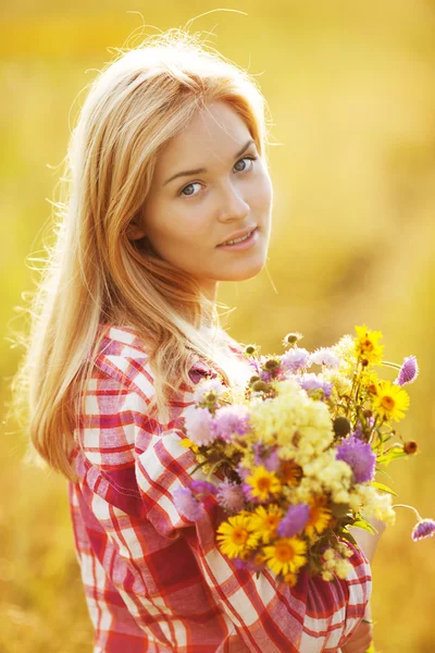 Glad tjej med en bukett av blommor — Stockfoto