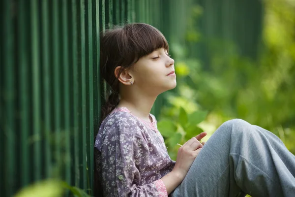 Glückliches kleines Mädchen sitzt und träumt — Stockfoto