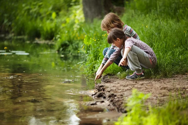 Junge mit einem Mädchen am Wasser — Stockfoto