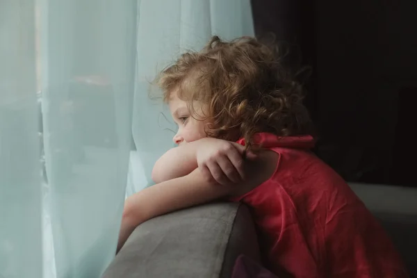 Girl waiting for someone and looking out the window — Stock Photo, Image