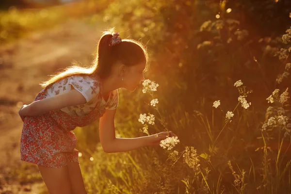 Malá holčička vonící divoká květina — Stock fotografie