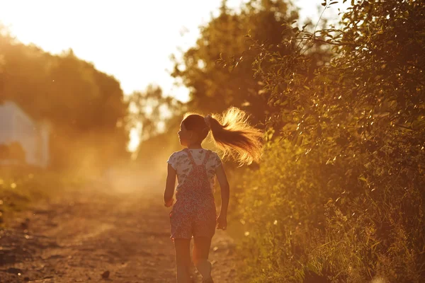 Happy girl running down a country road — Stock Photo, Image