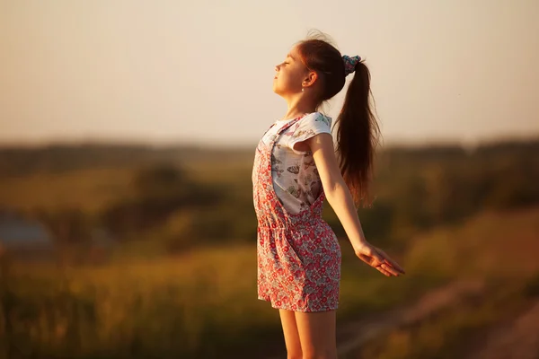 Happy little girl faces to the sun — Zdjęcie stockowe