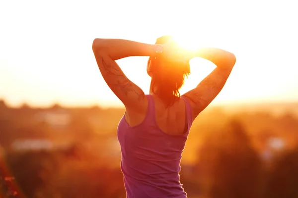 Gelukkig jonge vrouw bij zonsondergang — Stockfoto