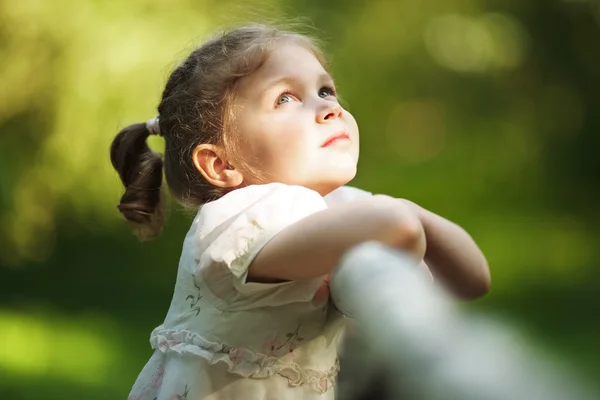 Pequena menina bonita feliz olhando para cima — Fotografia de Stock