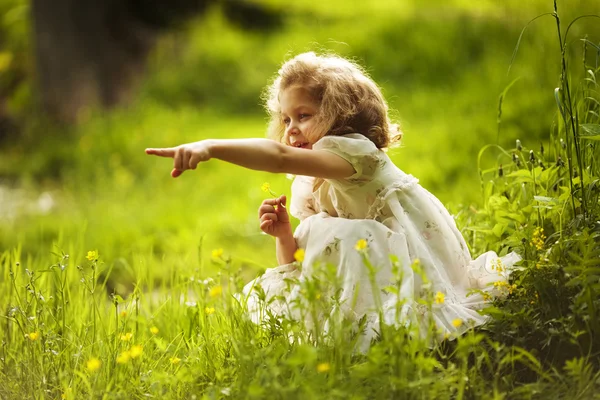 Meisje met een bloem geeft ergens hand — Stockfoto