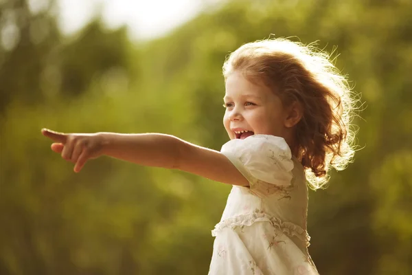 Happy curly girl showing hand forward — Stock Photo, Image