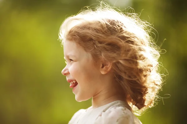 Glückliches kleines Mädchen mit zerzausten Haaren — Stockfoto