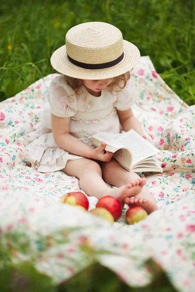 Mała dziewczynka siedzi i czyta książkę — Zdjęcie stockowe