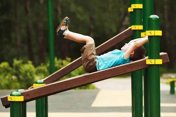 Exercício de menino no playground Fotografia De Stock