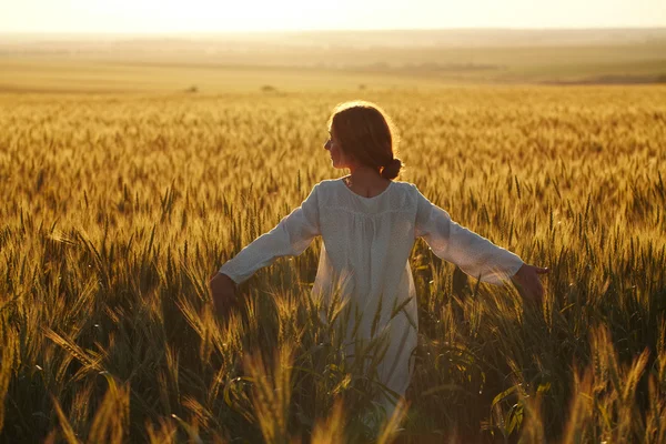 Felice giovane donna tra i campi al tramonto — Foto Stock