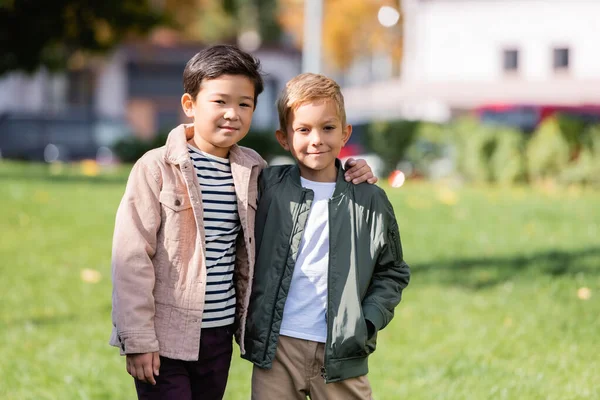 Sonriente Asiático Chico Abrazando Amigo Parque — Foto de Stock