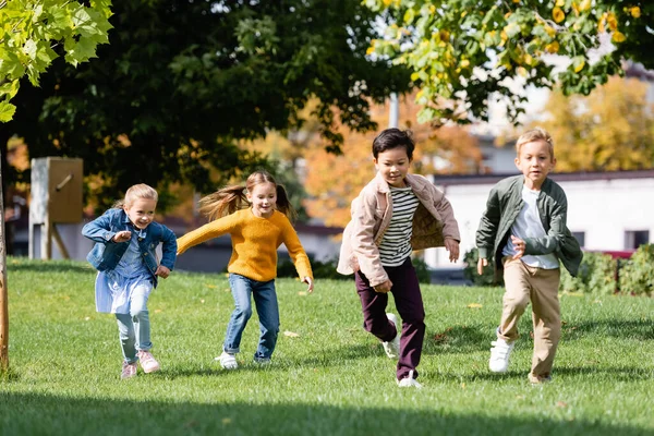 Sonrientes Niños Multiétnicos Corriendo Sobre Hierba Parque — Foto de Stock