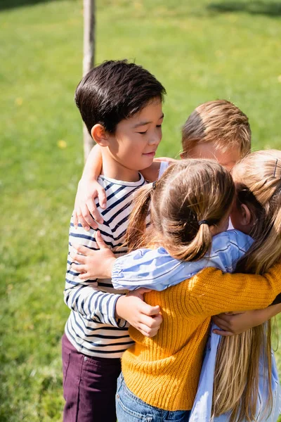 Asian Boy Hugging Friends Blurred Foreground Park — Stock Photo, Image