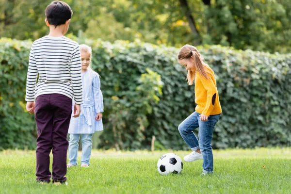 Chica Sonriente Jugando Fútbol Cerca Amigos Césped Cubierto Hierba — Foto de Stock