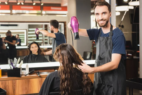 Peluquero Alegre Secado Pelo Del Cliente Mientras Mira Cámara Cerca — Foto de Stock