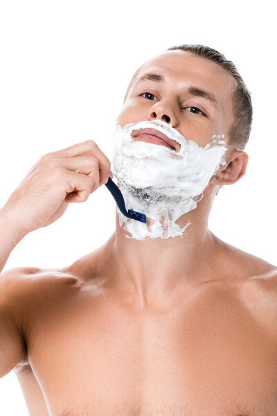 sexy shirtless man with foam on face shaving isolated on white