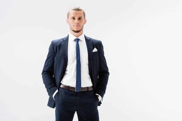 Joven Hombre Negocios Traje Posando Con Las Manos Bolsillos Aislados — Foto de Stock