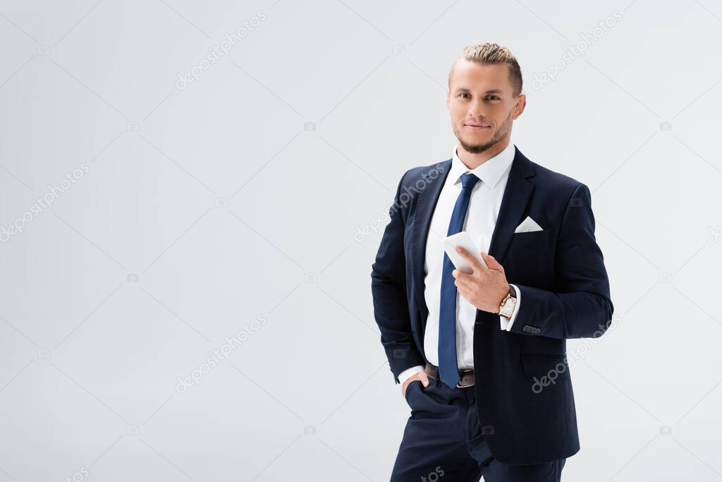 young businessman in suit with smartphone isolated on white