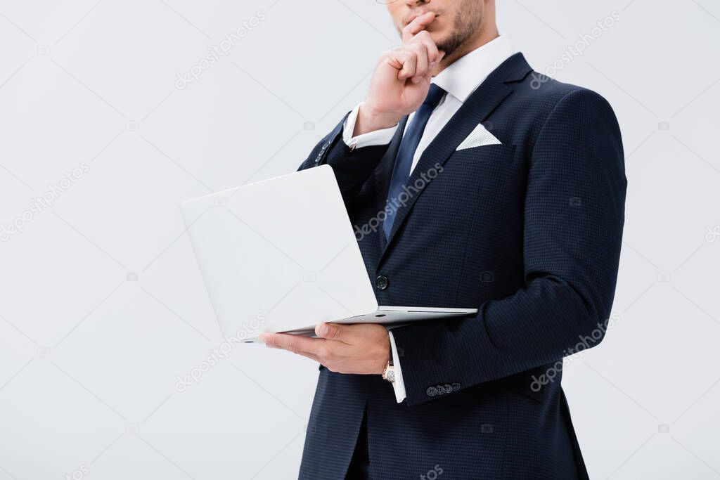 cropped view of pensive young businessman in suit with laptop isolated on white
