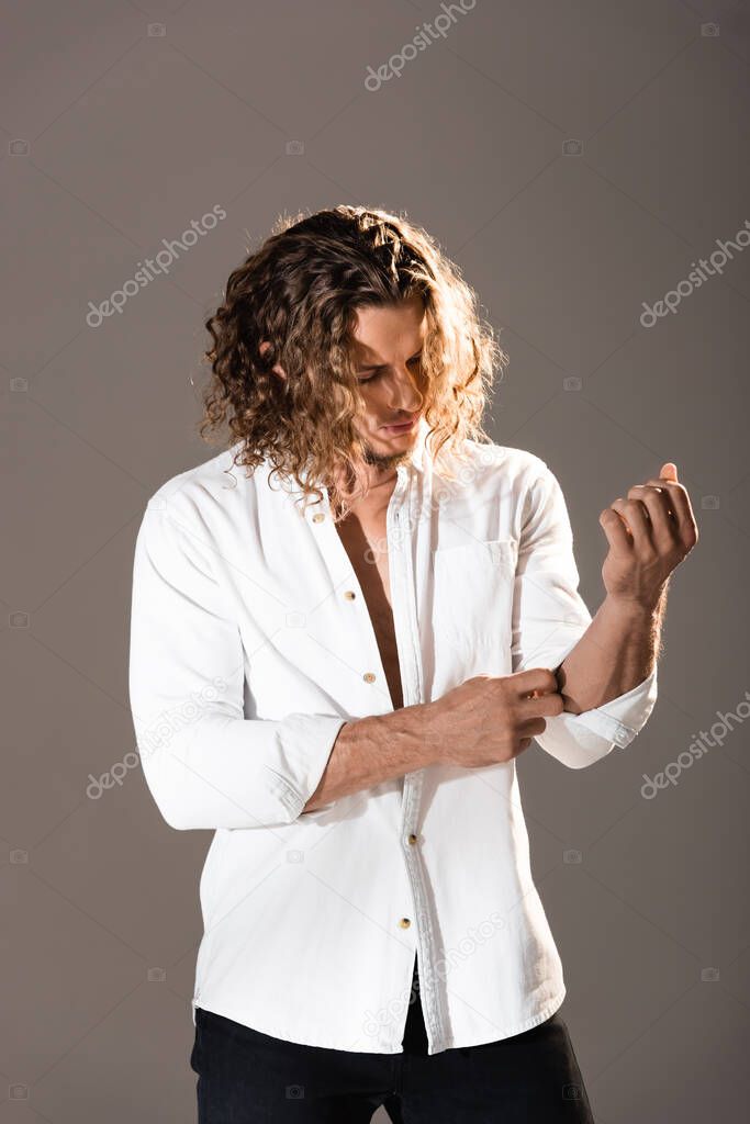 sexy man with unbuttoned shirt posing on dark background