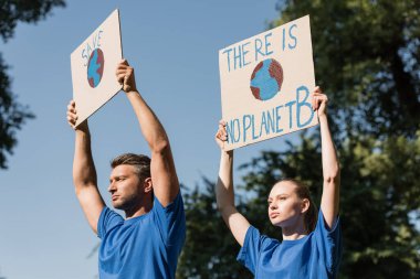 couple of activists holding posters with globe and there is no planet b inscription, ecology concept clipart
