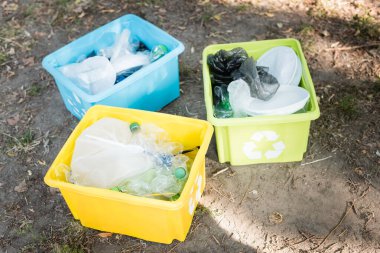 Geri dönüşüm sembollü kaplar, plastik atıklarla dolu, ekoloji konsepti