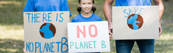 family of volunteers holding placards with globe, save, and no planet b inscription, ecology concept, banner
