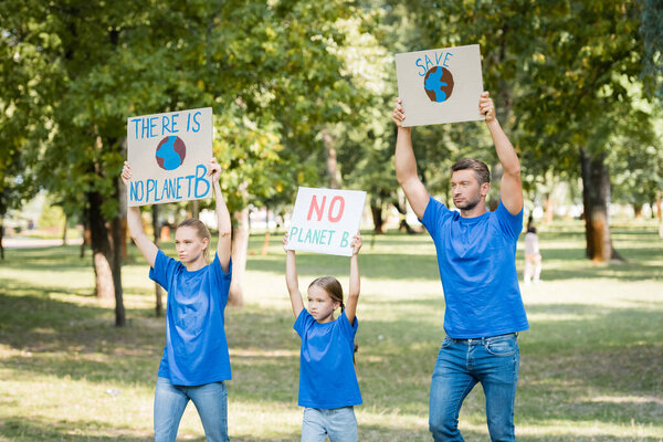 family holding posters with globe, there is no planet b planet, and save inscription in raised hands, ecology concept