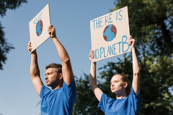 couple of activists holding posters with globe and there is no planet b inscription, ecology concept