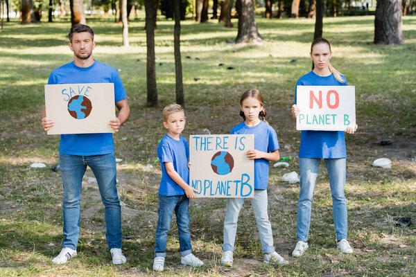 two children and parents holding posters with globe and there is no planet b inscription, ecology concept