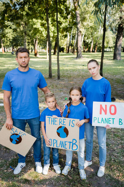 семья волонтеров, держащих плакаты с земным шаром и без надписи на планете б, экологическая концепция