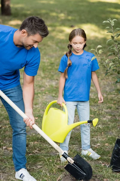 Vader Graven Grond Dochter Houden Gieter Buurt Van Jonge Boom — Stockfoto