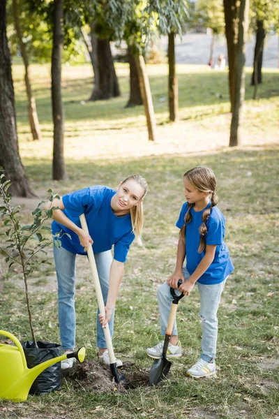 Woman Looking Camera While Digging Ground Daughter Young Tree Watering — Stock Photo, Image